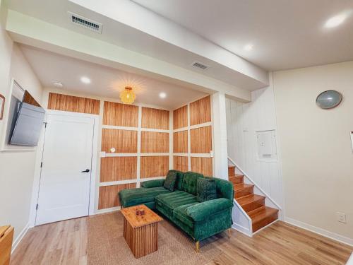 a living room with a green couch and stairs at Stylish 2 BR 1 BA Apartment - Steps to the Ocean - Hidden Gem in Wildwood