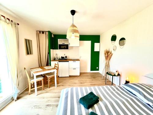 Un dormitorio con una cama y una mesa y una cocina. en Cocooning appartement, en Joué-lès-Tours