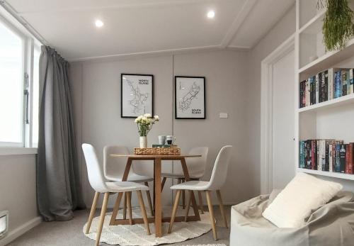 a dining room with a table and white chairs at Guest Wing on Glasgow in Feilding