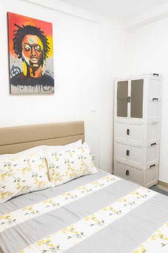 a bedroom with a bed and a painting on the wall at Résidence Luxe Dakar Centre Ville in Dakar