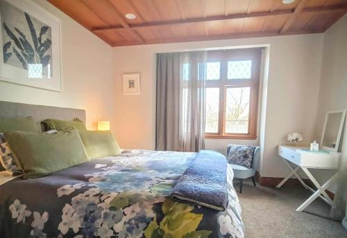 a bedroom with a bed and a desk and a window at Guest Wing on Glasgow in Feilding