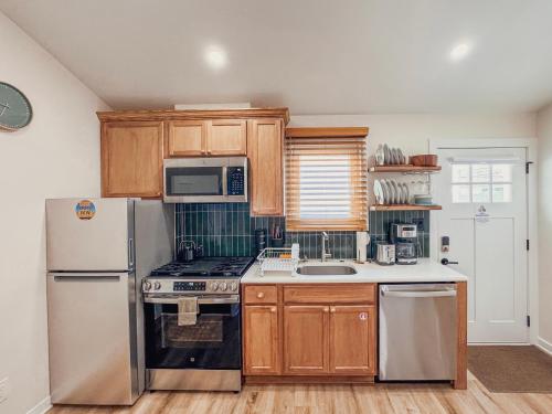 a kitchen with wooden cabinets and a white refrigerator at Stylish 2 BR 1 BA Apartment - Steps to the Ocean - Hidden Gem in Wildwood