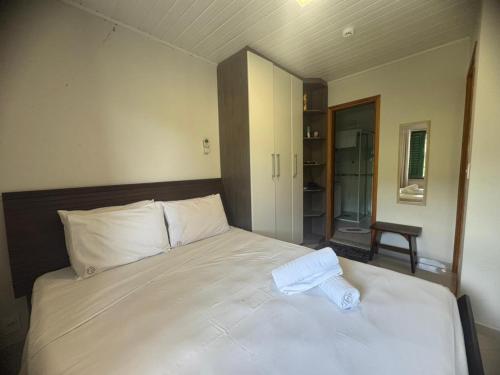 Un dormitorio con una cama grande con sábanas blancas. en Cavalinho Branco 305 suíte com varanda, en Águas de Lindóia