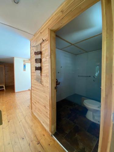 a bathroom with a toilet in a room at Posada de Expediciones Kahuel in Chaitén