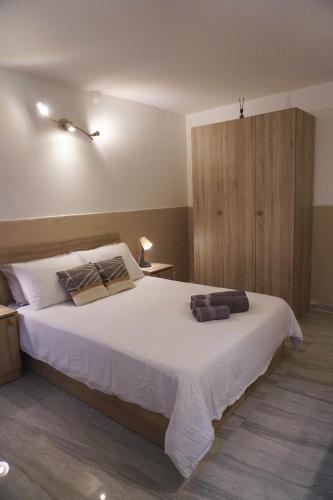 een slaapkamer met een groot wit bed en een houten kast bij San Nikola Getaway in Sliema