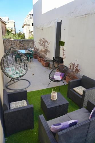 een patio met banken en stoelen en een tafel bij San Nikola Getaway in Sliema