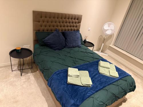 ein Schlafzimmer mit einem Bett mit blauen Laken und blauen Kissen in der Unterkunft Centenary Netho - Leeds City Centre in Central Station