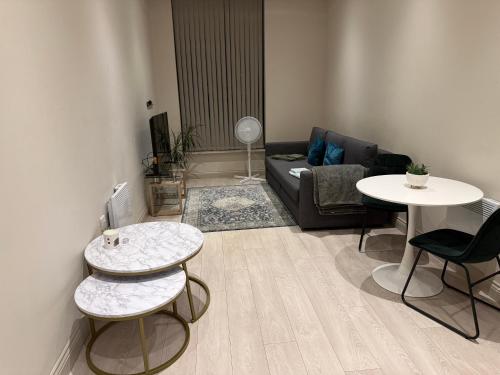 a living room with a couch and two tables at Centenary Netho - Leeds City Centre in Central Station