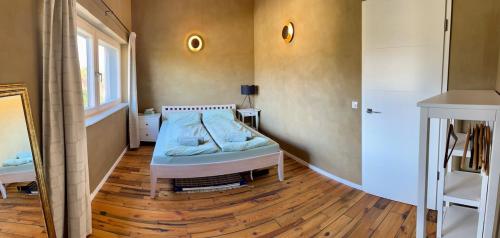 a bedroom with a bed and a wooden floor at okoTime - Studio mit Dachterrasse in Birkenwerder