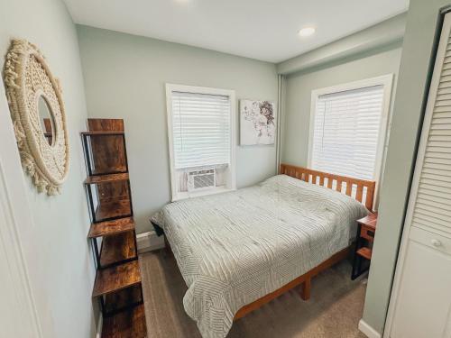a bedroom with a bed and two windows at Ultra Modern - Entire 3 Bedroom Apartment - 5 min walk to the Beach in Wildwood