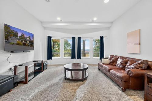 a living room with a leather couch and a tv at Mountain retreat w deck, game room & dog-friendly in Hedgesville