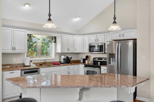 a kitchen with white cabinets and a granite counter top at Mountain retreat w deck, game room & dog-friendly in Hedgesville