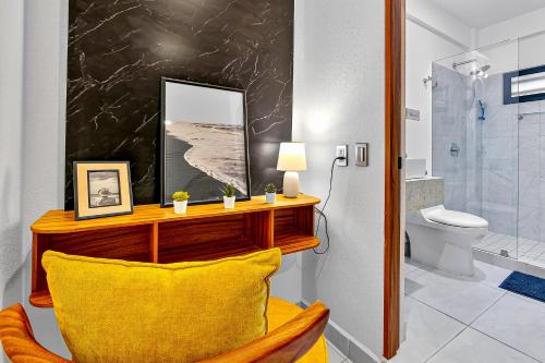 ein Badezimmer mit einem gelben Stuhl und einem Spiegel in der Unterkunft Sunlit Terra Haven at Pacifico Residencial in Jarretadera