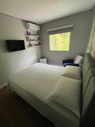 Un dormitorio con una cama grande y una ventana en Quarto privativo em Brusque próximo ao hospital e centro, en Brusque