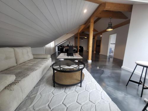 a living room with a couch and a table at Le loft in Villarsel-le-Gibloux