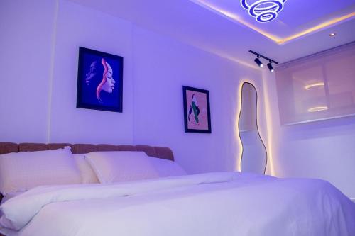 a bedroom with two beds with lights on it at PWJ Apartments in Lagos