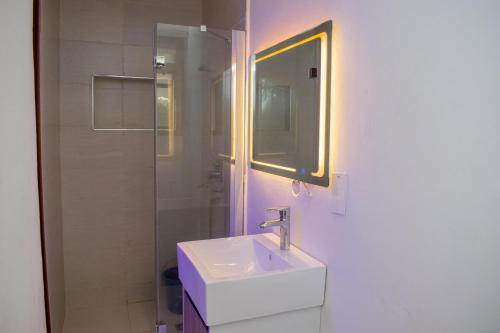 a white bathroom with a sink and a mirror at PWJ Apartments in Lagos