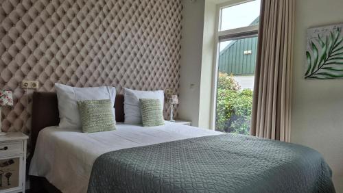 een slaapkamer met een groot bed met een groot raam bij B&B vakantieappartementen Dalerheugte in Dalerveen