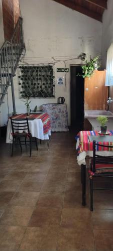 un salon avec une table et des chaises et un escalier dans l'établissement Hostal la caleta, à Salta