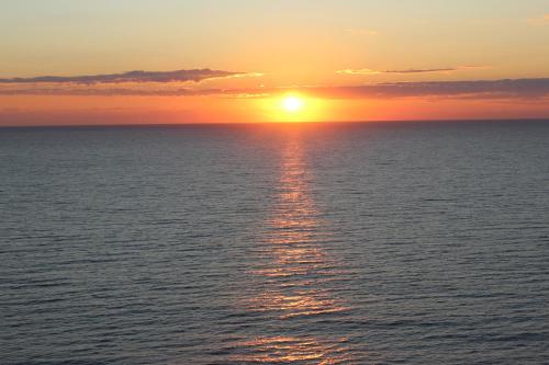 a sunset over the ocean with the sun setting at Oceanview Condo Right On the Beach with Incredible Resort Amenities in Myrtle Beach