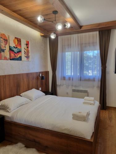 une chambre avec un grand lit et une fenêtre dans l'établissement Royal Garden Centar apartmani, à Zlatibor