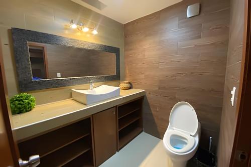 a bathroom with a sink and a toilet and a mirror at Casa El Tular - Alberca priv / a 5 min de la playa in Colonia Miramar