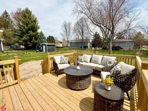 a wooden deck with couches and tables on it at Cozy 3BR Retreat - Modern Finish & Great Location in Bettendorf