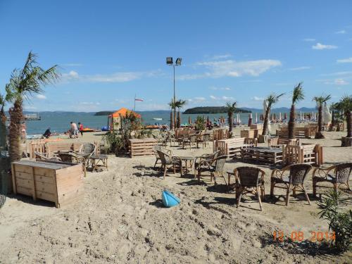 una playa con mesas y sillas en la arena en Casa vacanze Tuoro, en Tuoro sul Trasimeno