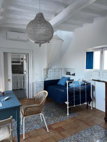 a living room with a blue bed and a lamp at Casa Aimee in Stromboli
