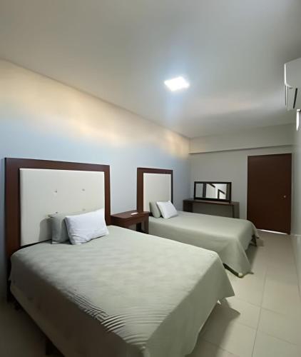 a hotel room with two beds and a mirror at Casa Madre Perla - a 2 min de la Playa Miramar in Colonia Miramar