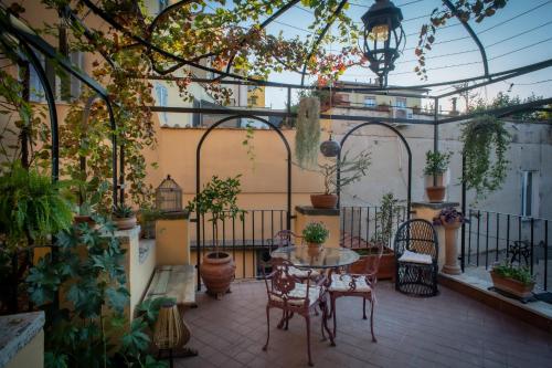 a patio with a table and chairs and plants at Appartamento con terrazza La Voliera di Bacco in Frascati
