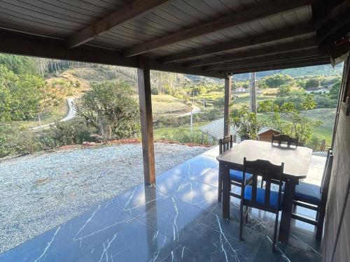 a table and chairs on a porch with a view at Cabana com Piscina in Annitapolis