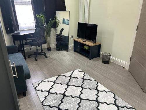 a living room with a television and a rug at Tooting Stays in London
