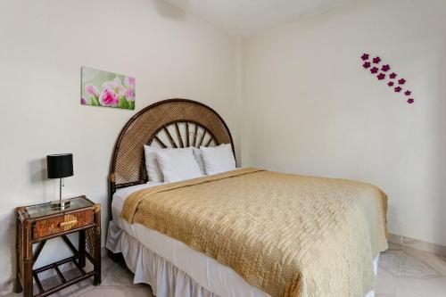 a bedroom with a bed and a side table at Departamento de la quinta in Playa del Carmen