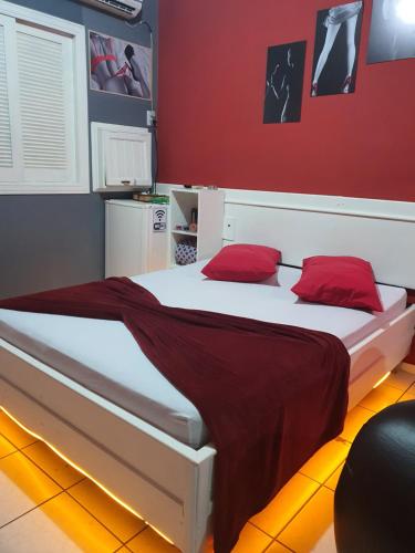 a bedroom with two beds with red walls at Motel A 2 in Criciúma