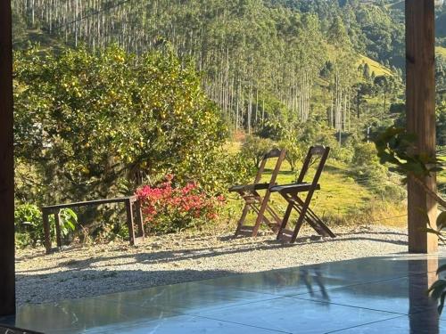 two wooden benches sitting on the side of a patio at Cabana com Piscina in Annitapolis