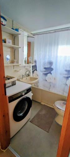 a bathroom with a toilet and a sink and a washing machine at CasaCorn in Stavrákion