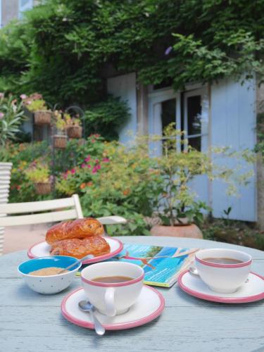 a table with cups of tea and pastries on it at L'Arbre D'Ange in Montmorillon