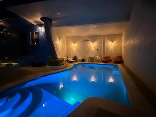 a large swimming pool in a room at night at Posada Nomad in San José del Cabo