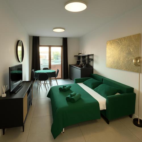 a bedroom with a green couch and a living room at Marisabella Suite Spa 4 in Bari