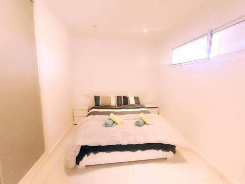 una camera da letto con un letto in una stanza bianca di 2 Bed Apartment close to the beach and Siam park ad Adeje