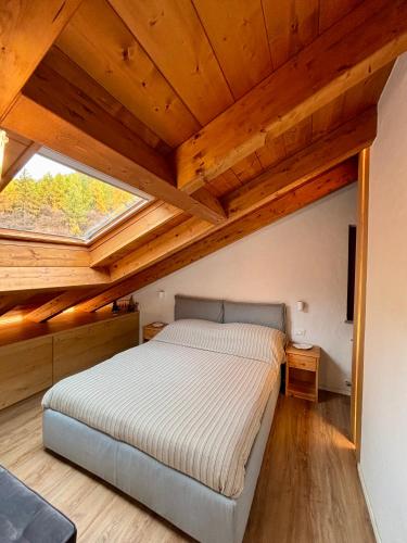 a bedroom with a bed in a room with wooden ceilings at Sky Lodge Bellamonte in Bellamonte