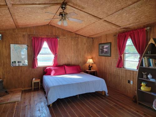 a bedroom with a bed with pink pillows and a ceiling at Private Retreat with Pond, Pool and Hot Tub in Boyd