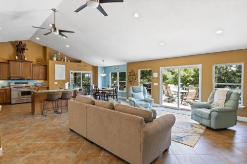 een woonkamer met een bank en stoelen en een keuken bij Sunrise, Wildlife & Paddle Boarding Awaits! in Sunrise Beach
