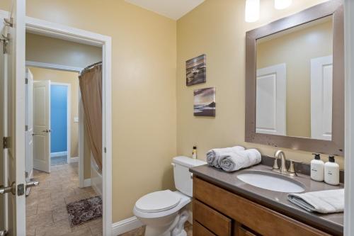 een badkamer met een toilet, een wastafel en een spiegel bij Sunrise, Wildlife & Paddle Boarding Awaits! in Sunrise Beach