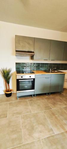 eine Küche mit Herd und Arbeitsplatte in der Unterkunft Charmante maison à Denain en couple ou solo in Denain