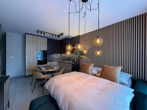 a bedroom with a large bed and a table with chairs at Apartmán Lottner in Kysucké Nové Mesto