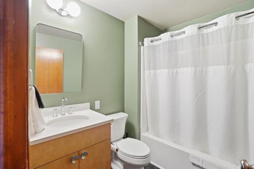a bathroom with a toilet and a sink and a shower at The Stoop On Spencer Drive in Van Wert