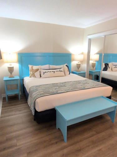a bedroom with a large bed with a blue headboard at Summer Sands - 401 by Sea Scape Properties in Wrightsville Beach