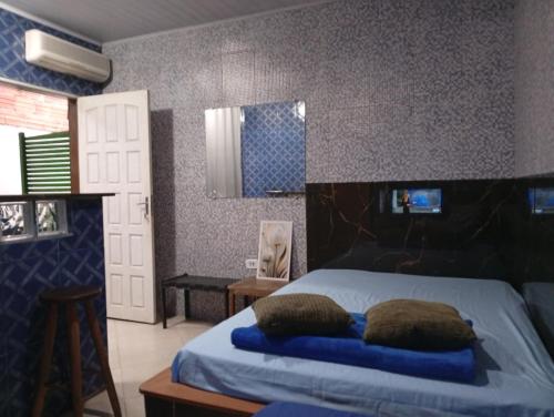 a bedroom with a bed with two pillows on it at CASAS e KITNETS NOSSO CANTINHO in Barra do Sahy